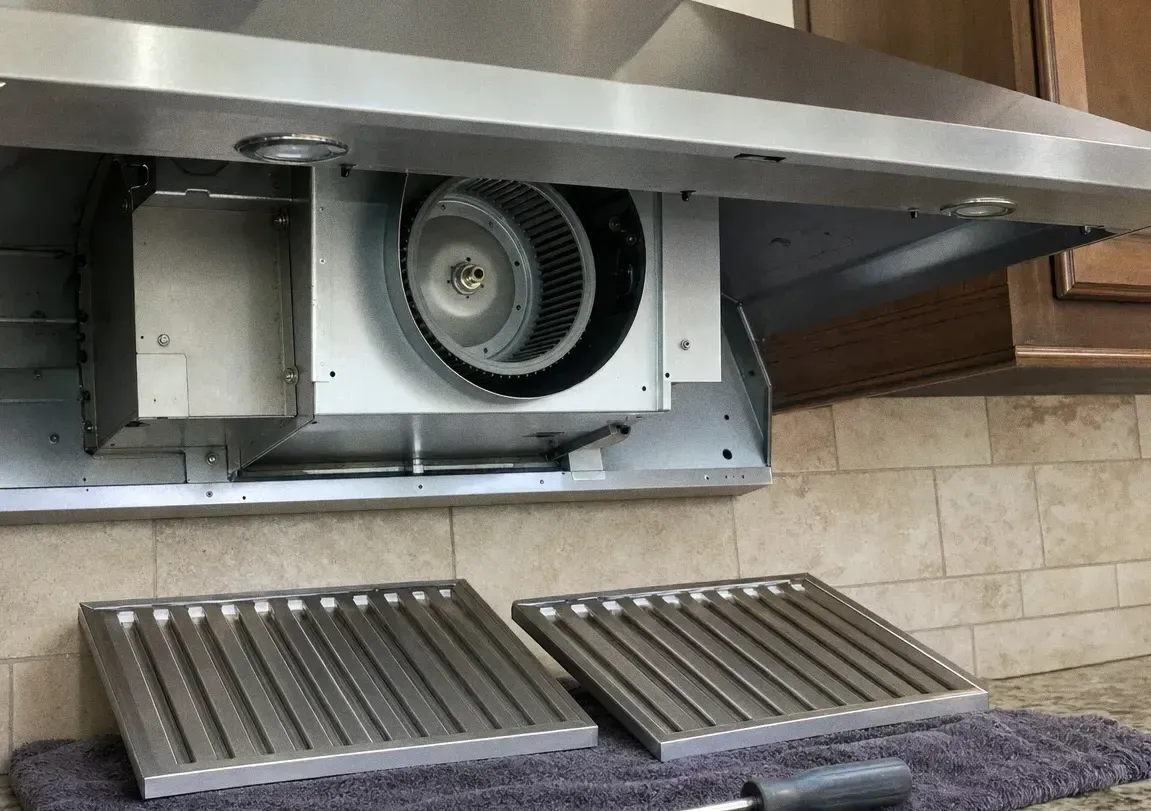 A ventilation hood removed from its housing with the squirrel-cage blower wheel visible inside